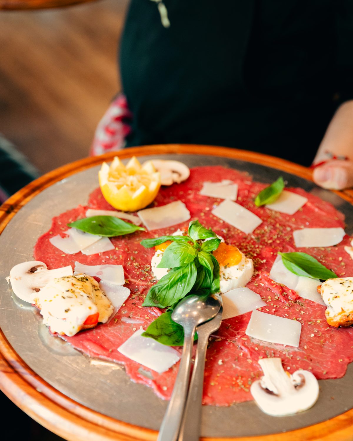 Carpaccio de bœuf, copeaux de parmesan, champignons crus et basilic.